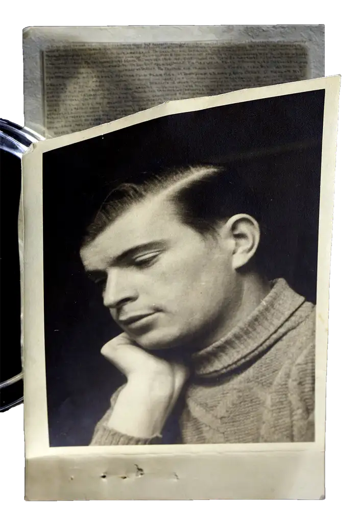 A photograph of a man with his face resting on his hand. A hidden message is viable on the inside.