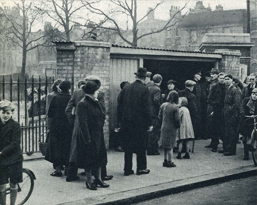 Newspaper clipping with a photo of people gathered outside the entrance.