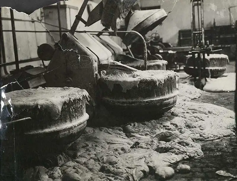 Black and white image of industrial vats – and the floor below them – overflowing with dough.