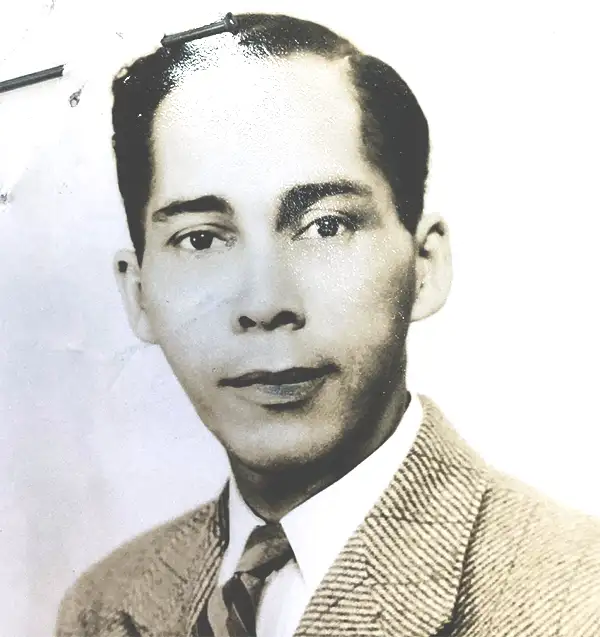 Passport-style photograph of a man wearing a suit and tie.