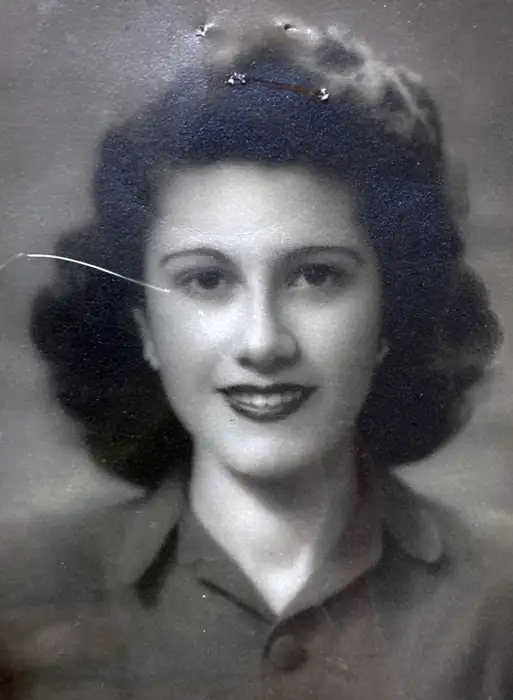 A passport-style photograph of a woman wearing a shirt.