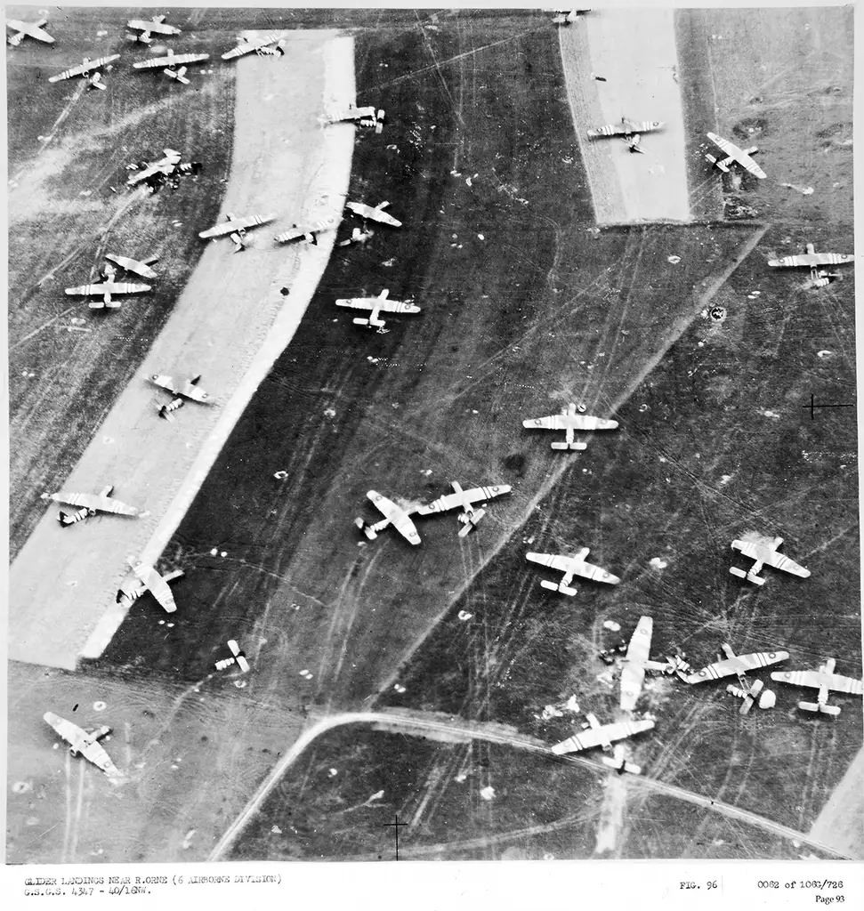 Aerial view of several dozen aircraft, many damaged, lying in a series of fields close to each other