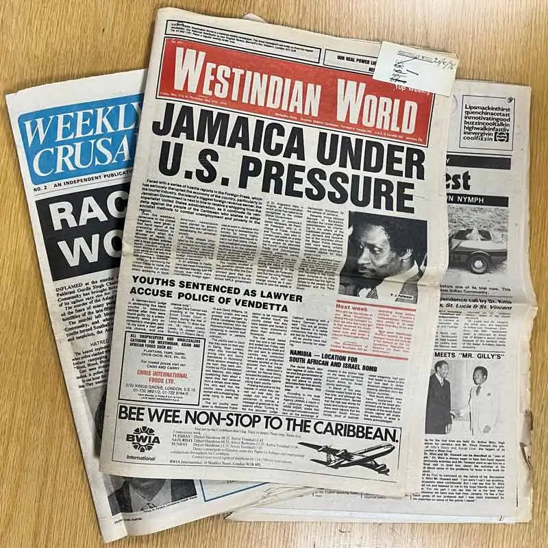 Three newspapers, the top one, 'West Indian World', headlined 'Jamaica under U.S. Pressure'.