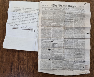 A handwritten court statement with a copy of a newspaper presented as evidence.