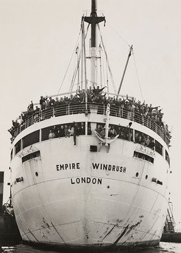 The front of a large passenger ship, packed with waving people.