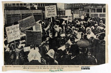 A newspaper clipping showing a photograph of a large group of strikers holding packards.