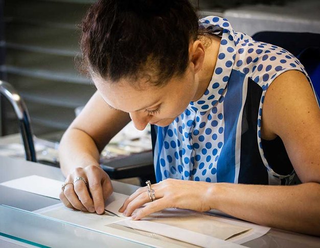 A colour photograph of conservation manager, Nicola Fleming, working on the will.