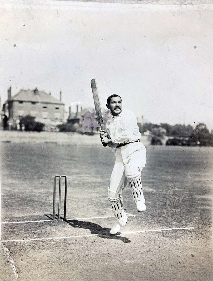 A cricket player jumping out of the crease to play a drive.