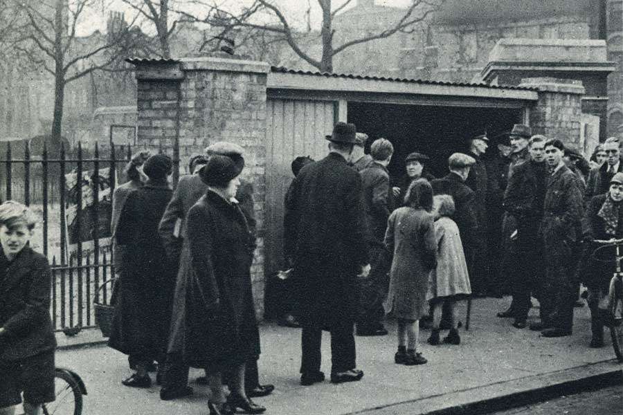 Newspaper clipping with a photo of people gathered outside the entrance.