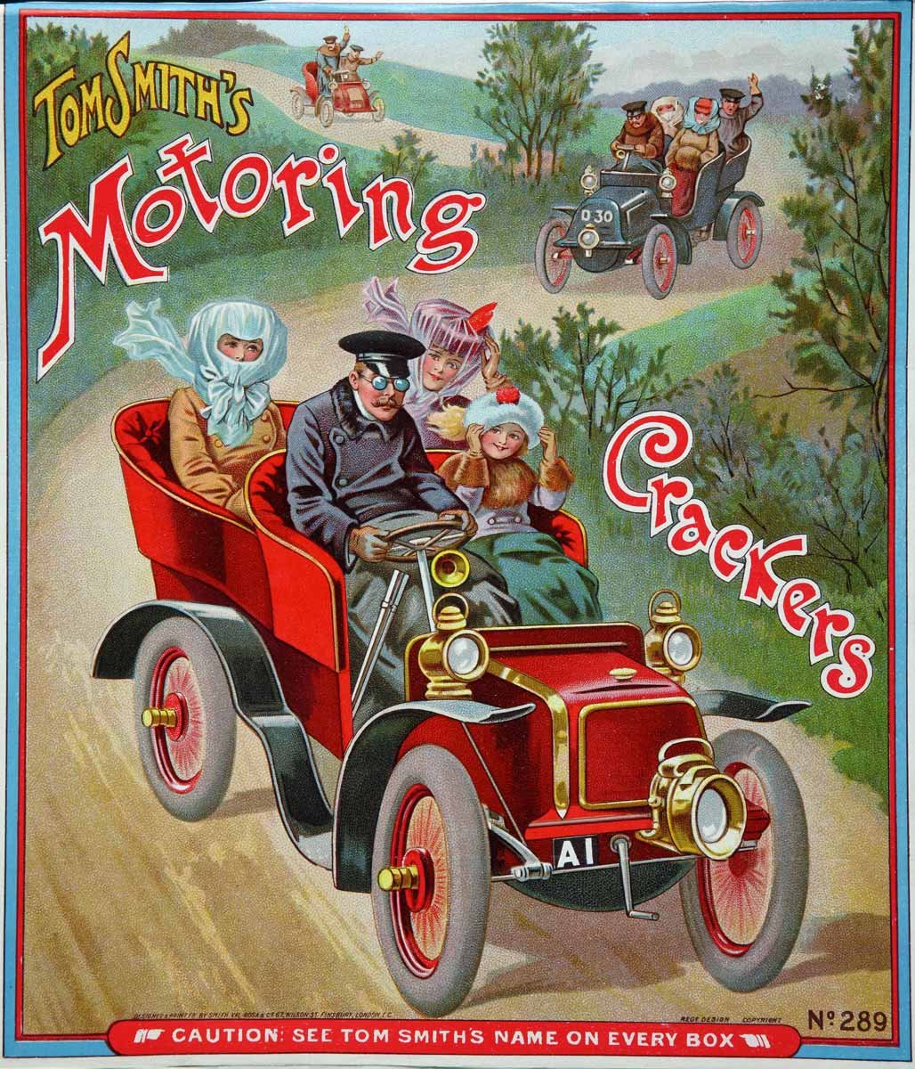 A man drives three children in a Victorian car through country lanes.