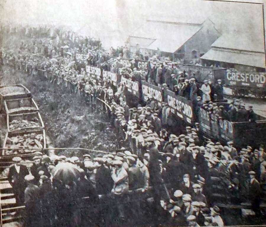 Hundreds of people gathered around the entrance to a coal mine.