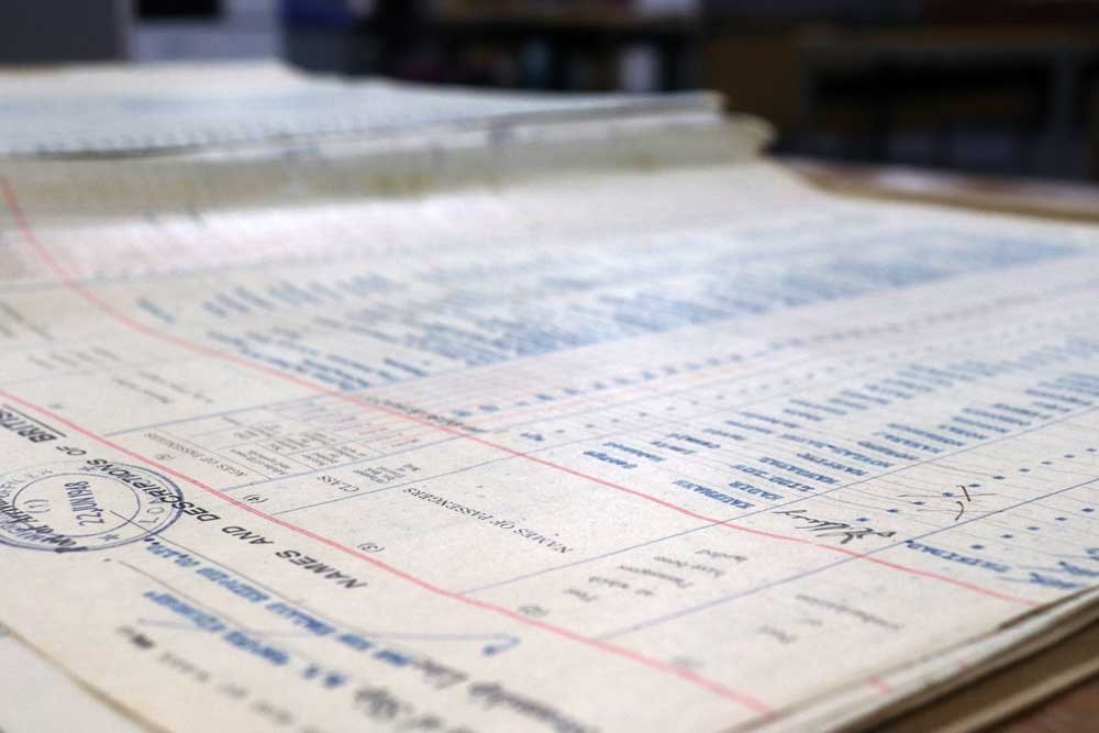 Colour photograph of a printed form on its side, completed in blue typewriter ink.