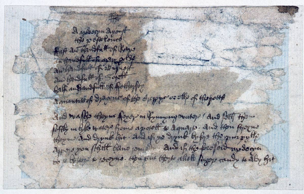 A badly damaged handwritten document with two paragraphs of text.