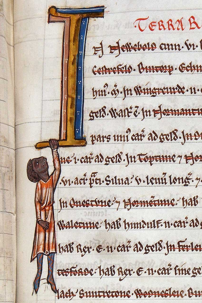 A detail of a medieval manuscript. The first letter is a large I with a black man dangling off it