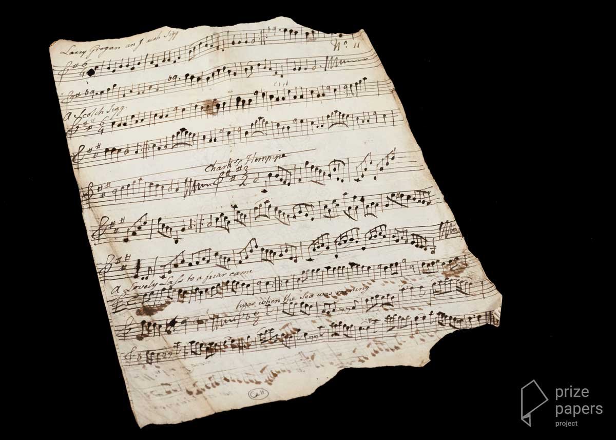 10 rows of slanted, hand-drawn sheet music on a page with torn edges.