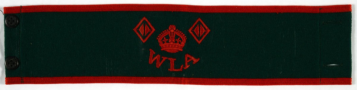 A dark arm band with a red insignia of a crown and the letters WLA