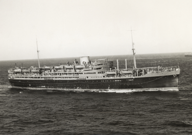 Black and white photo of a long passenger ship with one funnel and two sets of rigging for sails.