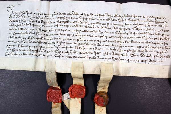 A document with eleven lines of handwritten Latin text and three red wax seals attached below.