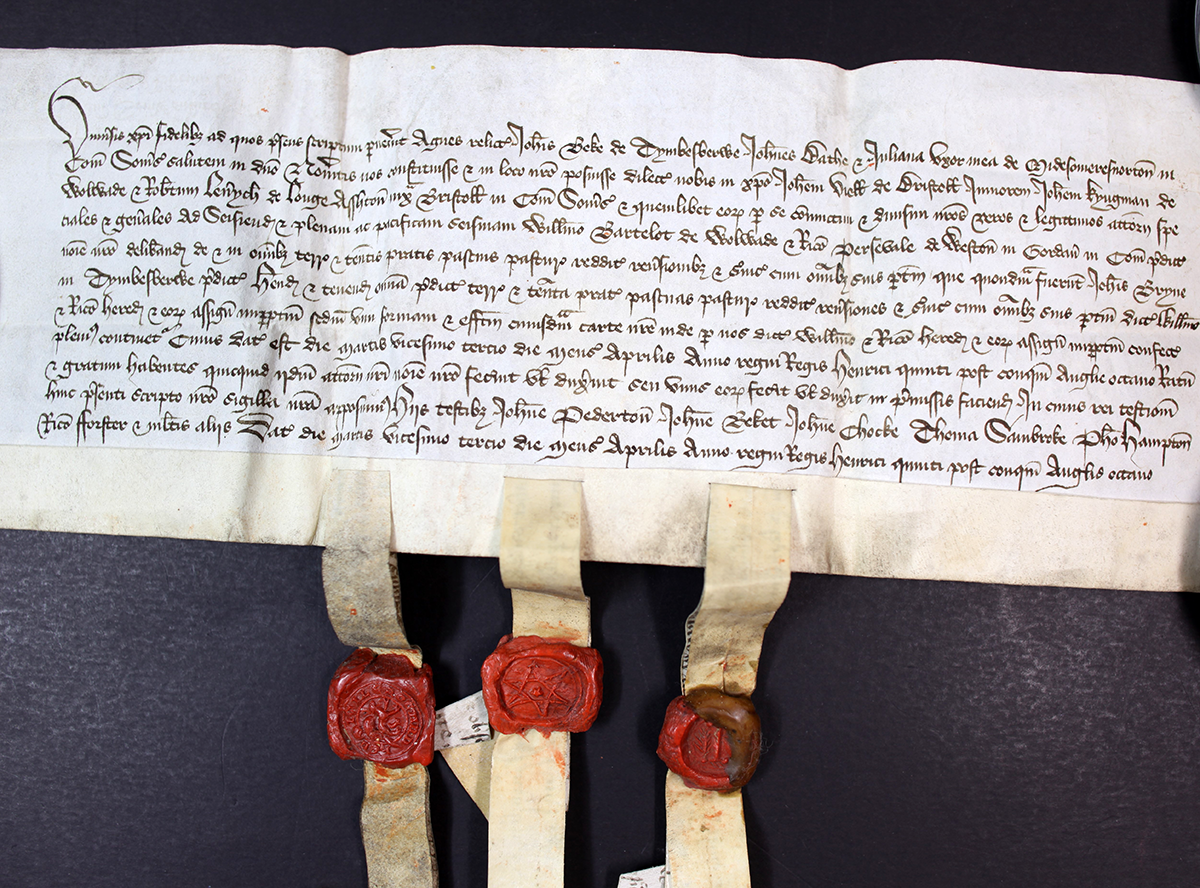 A document with eleven lines of handwritten Latin text and three red wax seals attached below.